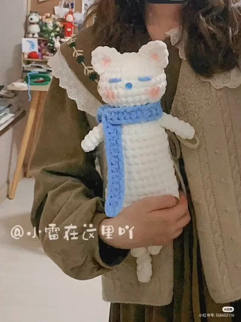 This may contain: a woman is holding a crocheted cat doll