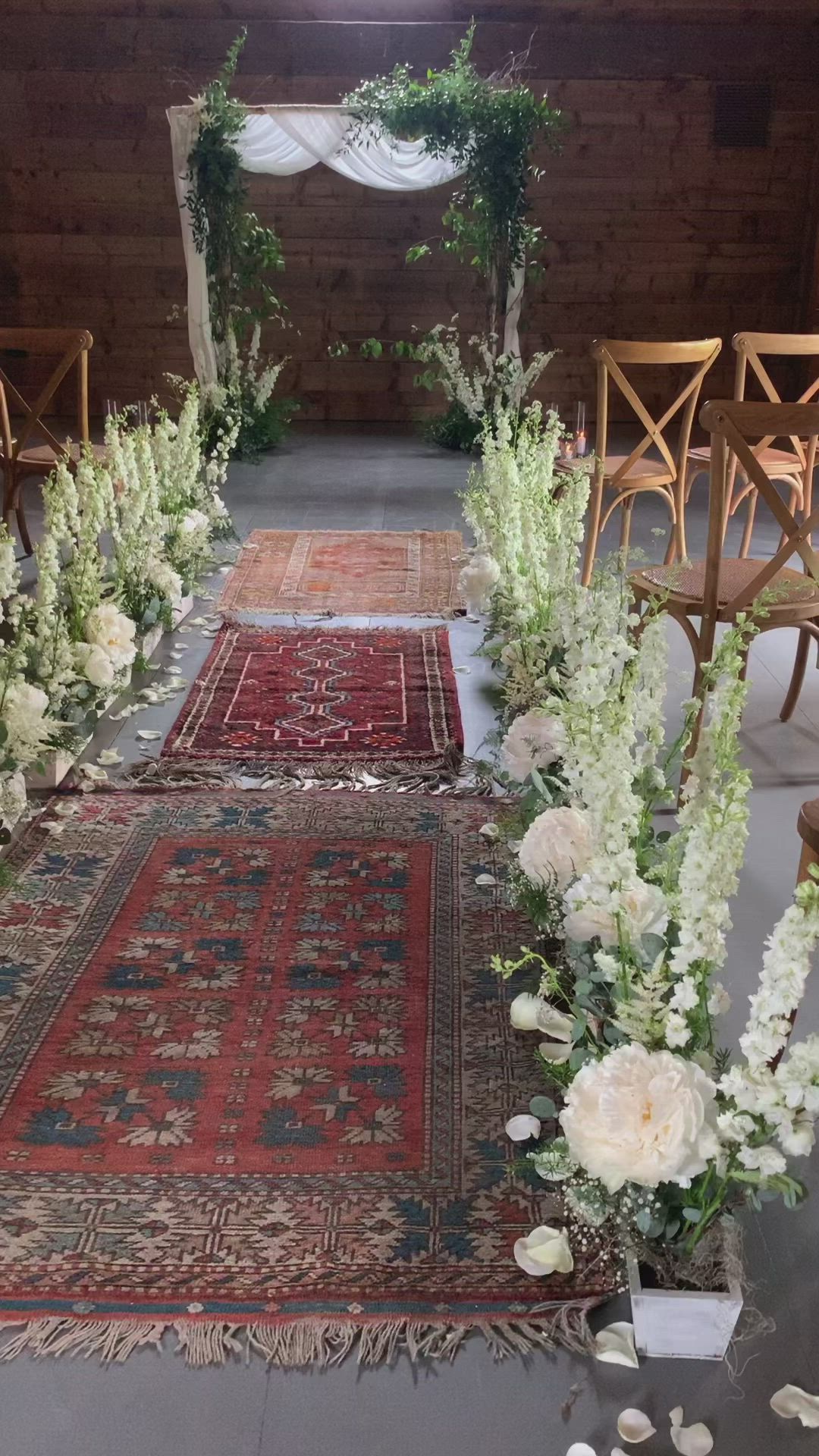 This may contain: the aisle is decorated with white flowers and greenery for an outdoor wedding ceremony in rustic style