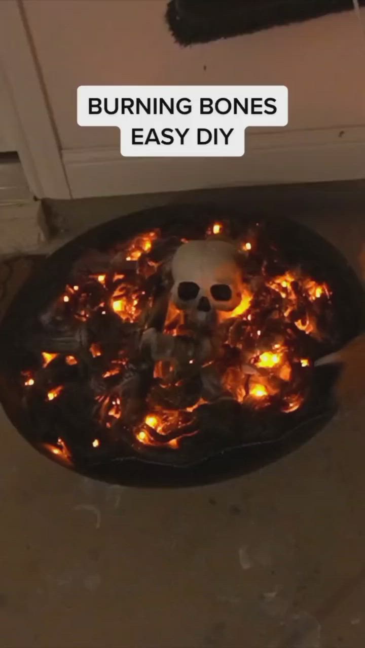 This may contain: a fire pit with burning bones in it