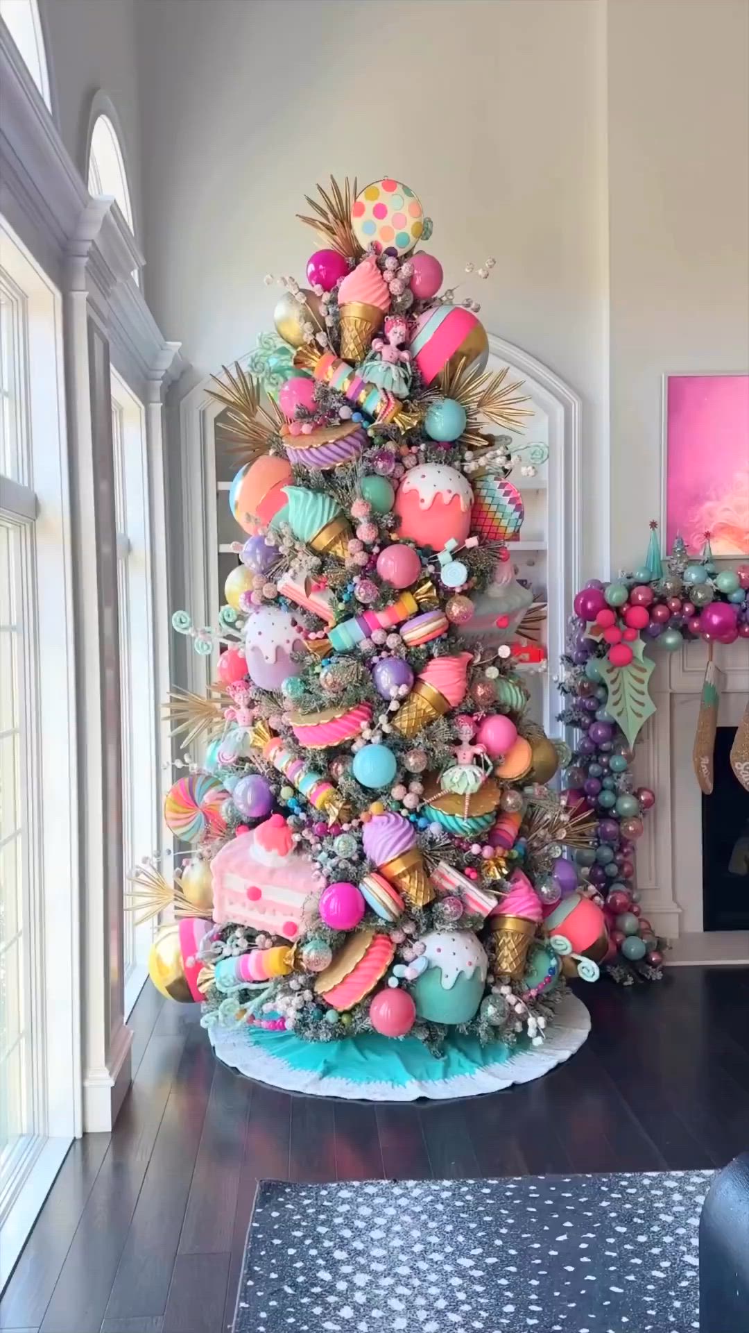 This may contain: a brightly colored christmas tree in the corner of a living room with pink and blue decorations