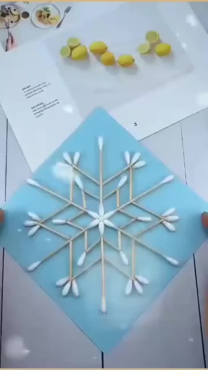 This may contain: a person holding up a snowflake made out of toothpicks and marshmallows