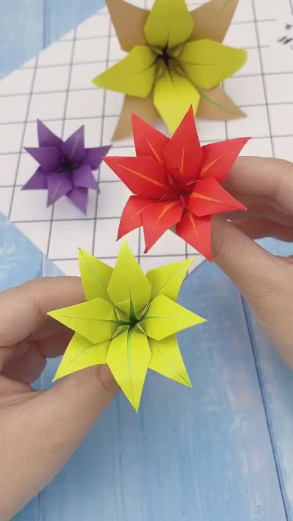 This may contain: someone is making origami flowers out of paper