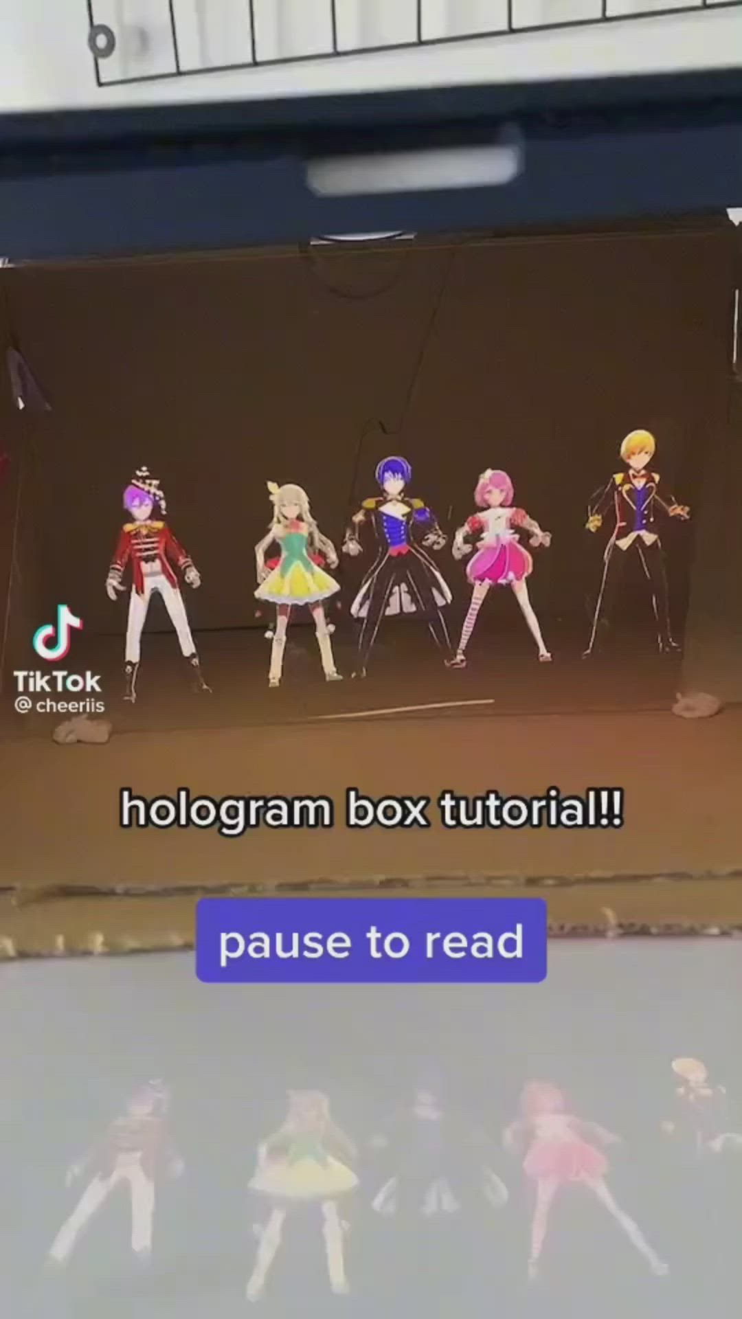 This may contain: there are many dolls on the stage with captioning that reads, hologgram box tutor pause to read