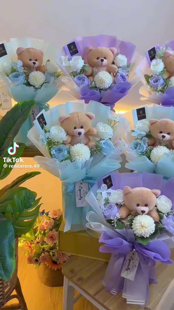 This may contain: a bunch of teddy bears with flowers in them