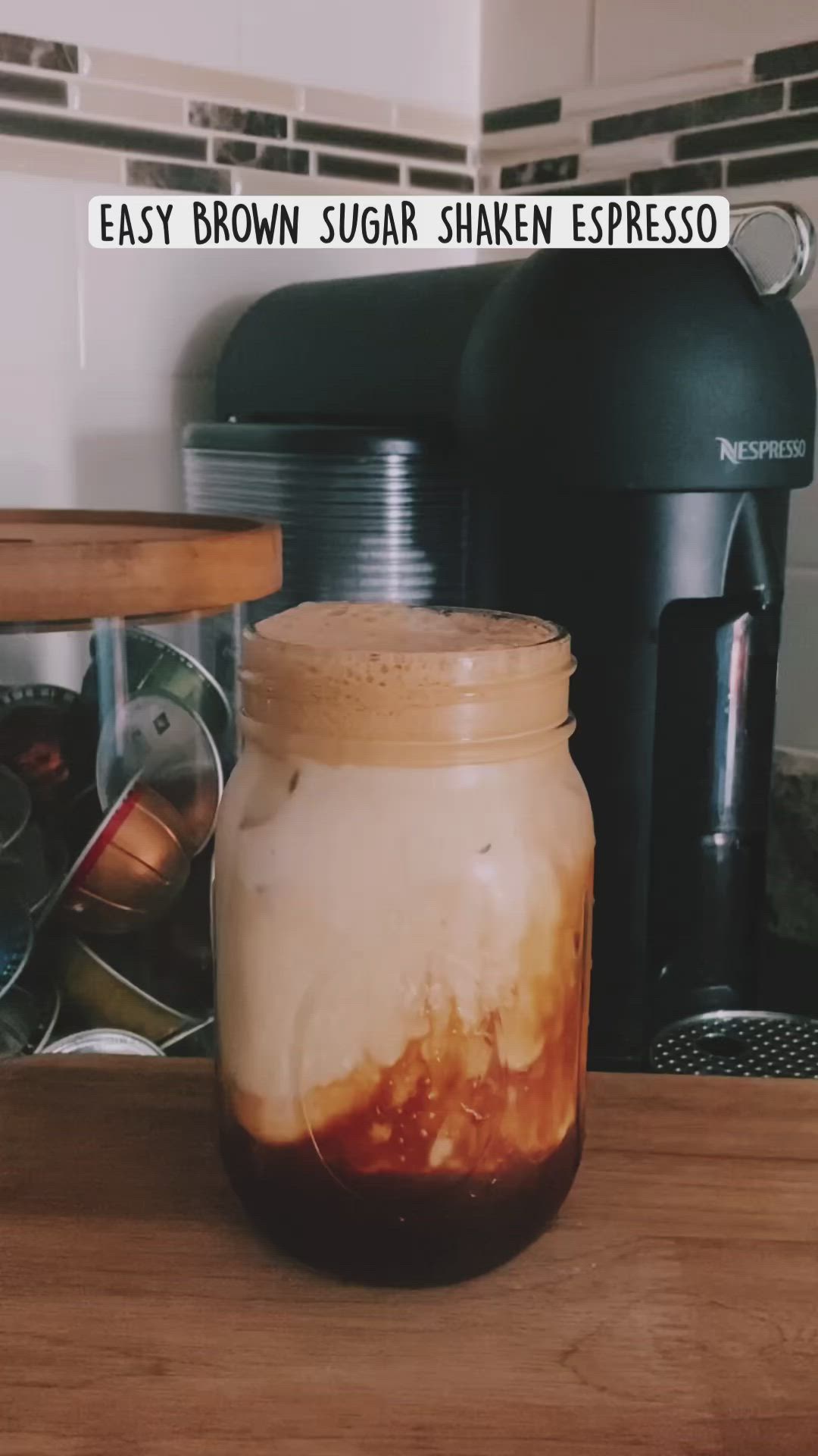 This may contain: a jar filled with liquid sitting on top of a wooden counter