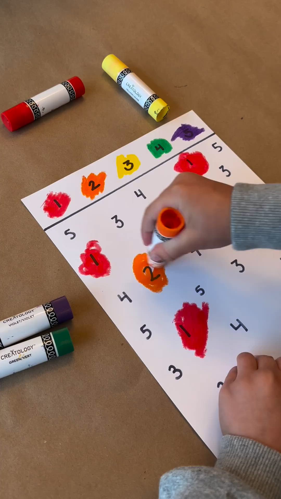 This may contain: a young boy is making letters with crayons on the table next to some crayons