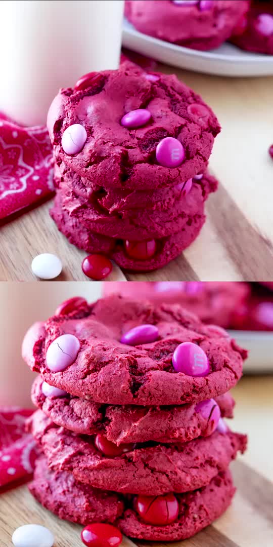 This may contain: red velvet cookies with pink and white chocolate chips are stacked on top of each other