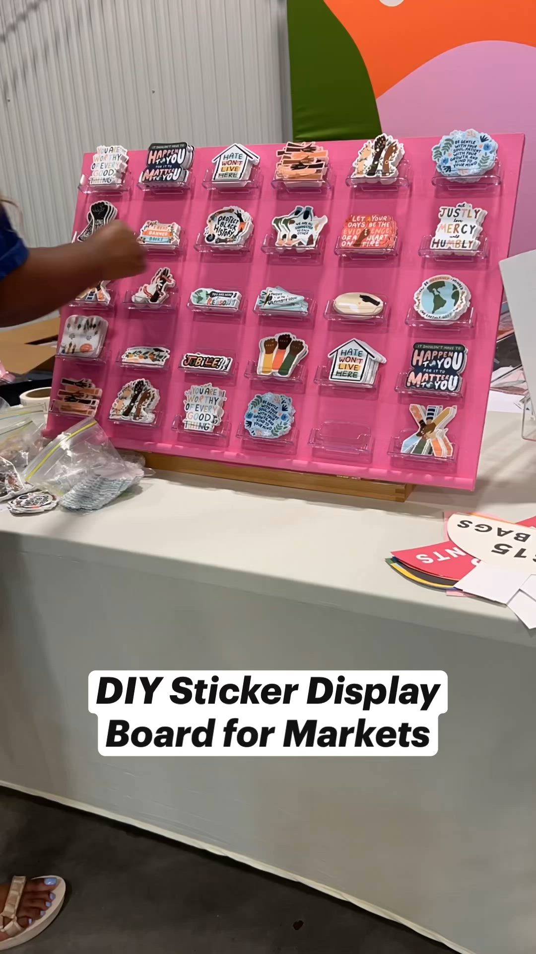 This may contain: a pink display board with lots of stickers on it and the words diy sticker display board for markets