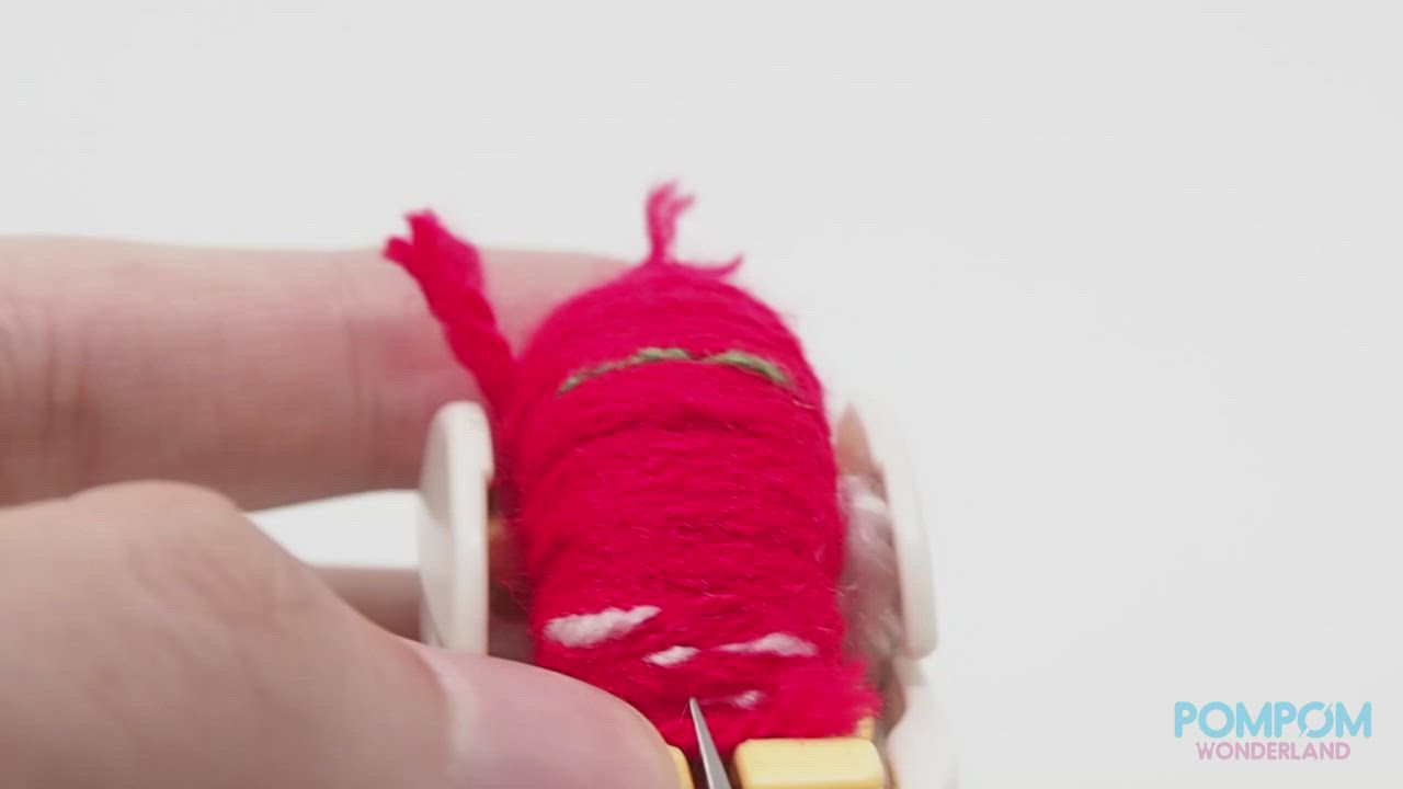 This may contain: a hand holding a small crocheted strawberry