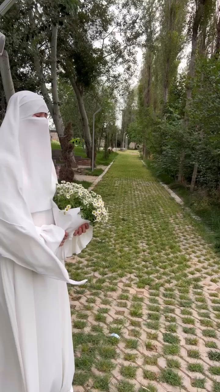 This may contain: a person dressed as a nun holding flowers