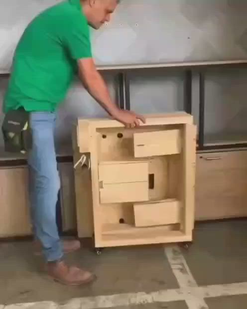 This may contain: a man in green shirt working on wooden furniture