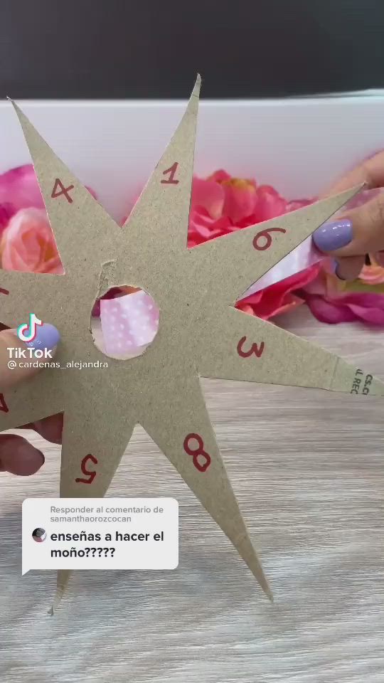 This may contain: a person holding up a paper star with numbers on it