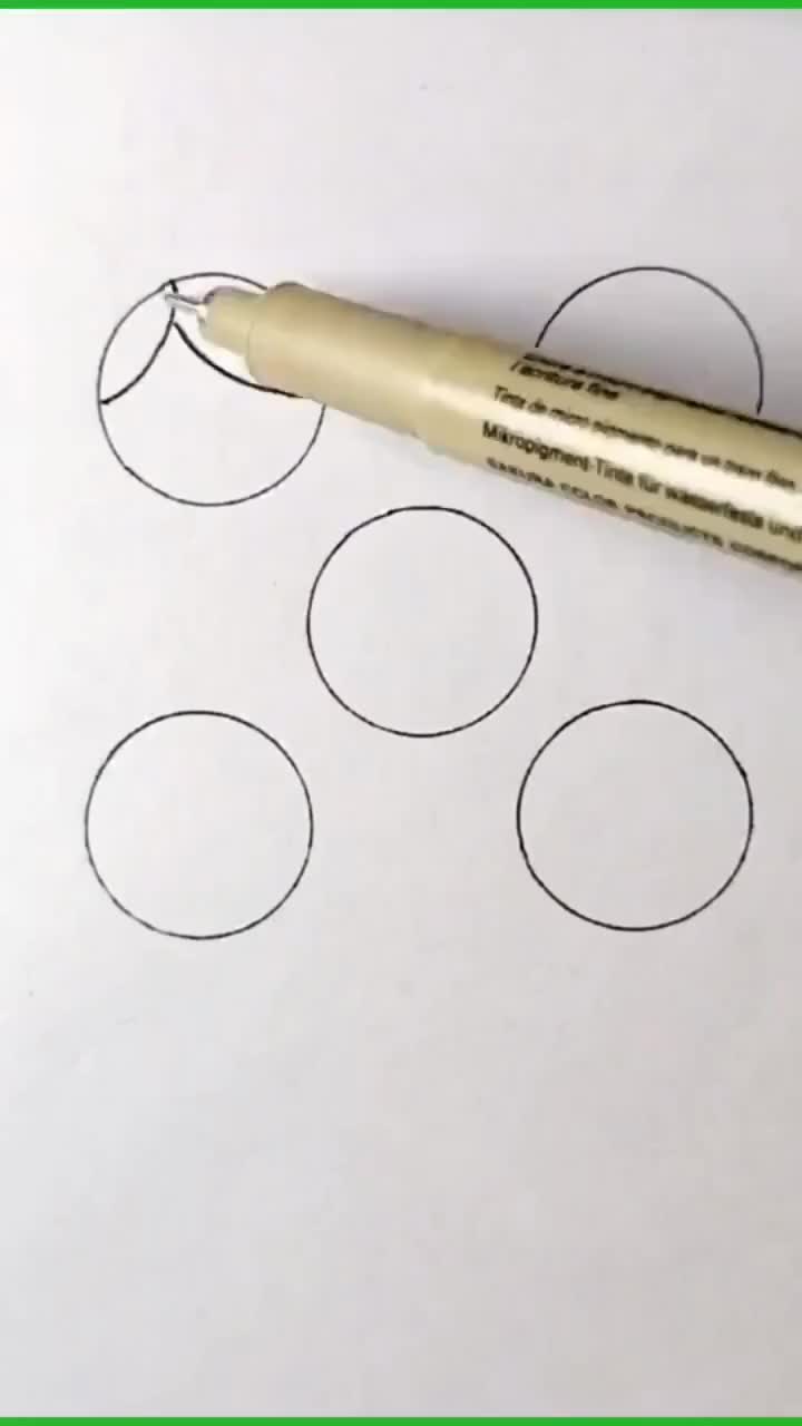 This may contain: a pen sitting on top of a piece of paper next to some circles and dots