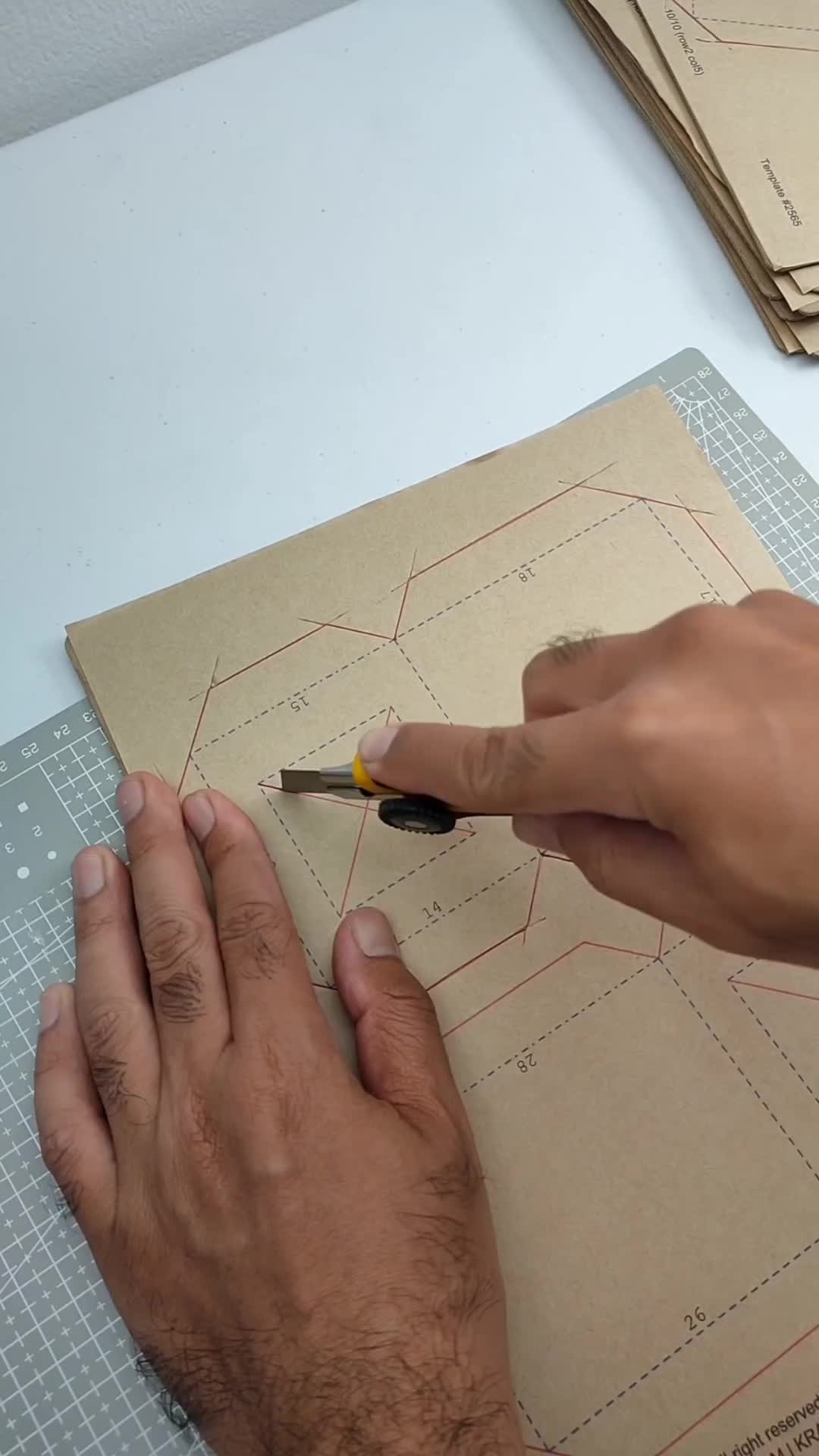 This may contain: a man is using a cardboard hammer to cut out a piece of paper on top of a table