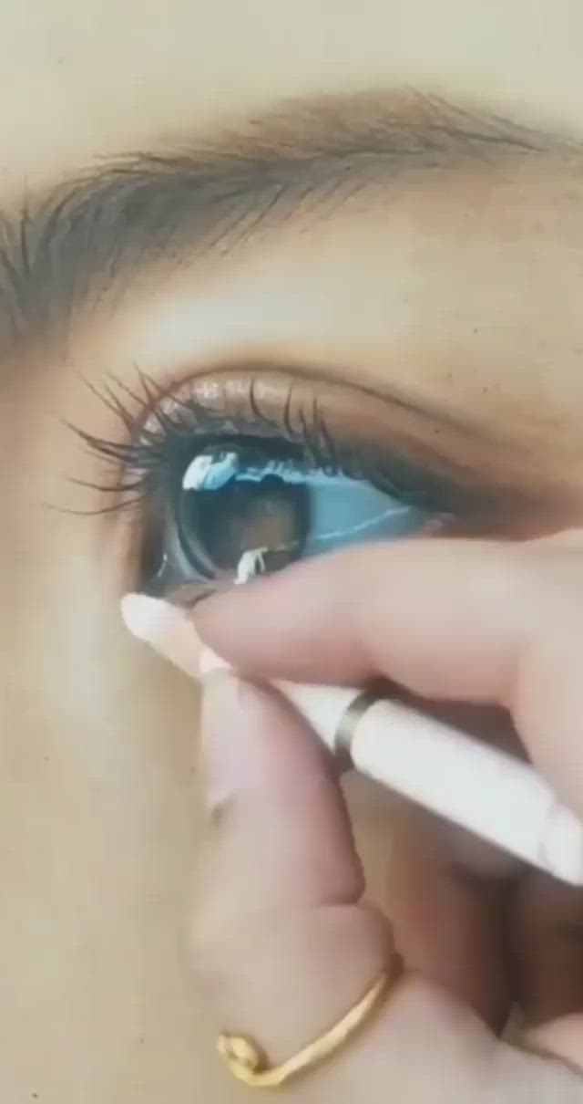 This may contain: a close up of a person holding a pen in front of an eye with the iris partially closed