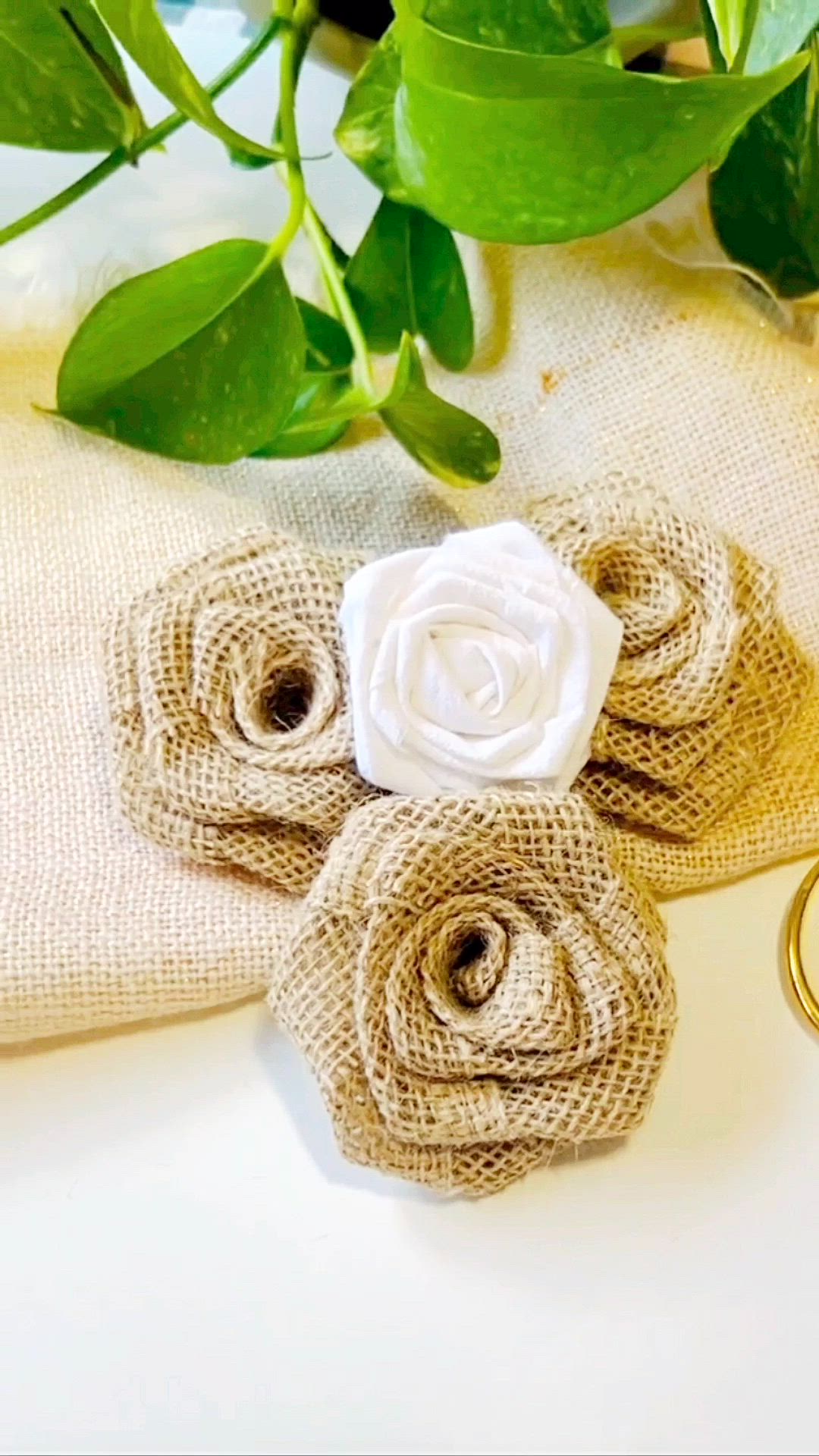 This may contain: two burlap flowers are sitting next to each other on a table with gold rings