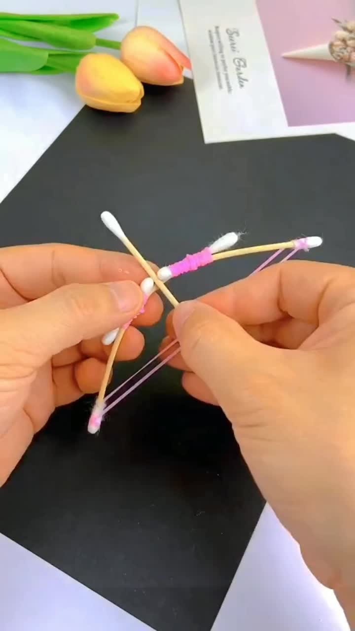 This may contain: two hands are holding toothbrushes on a black and white table