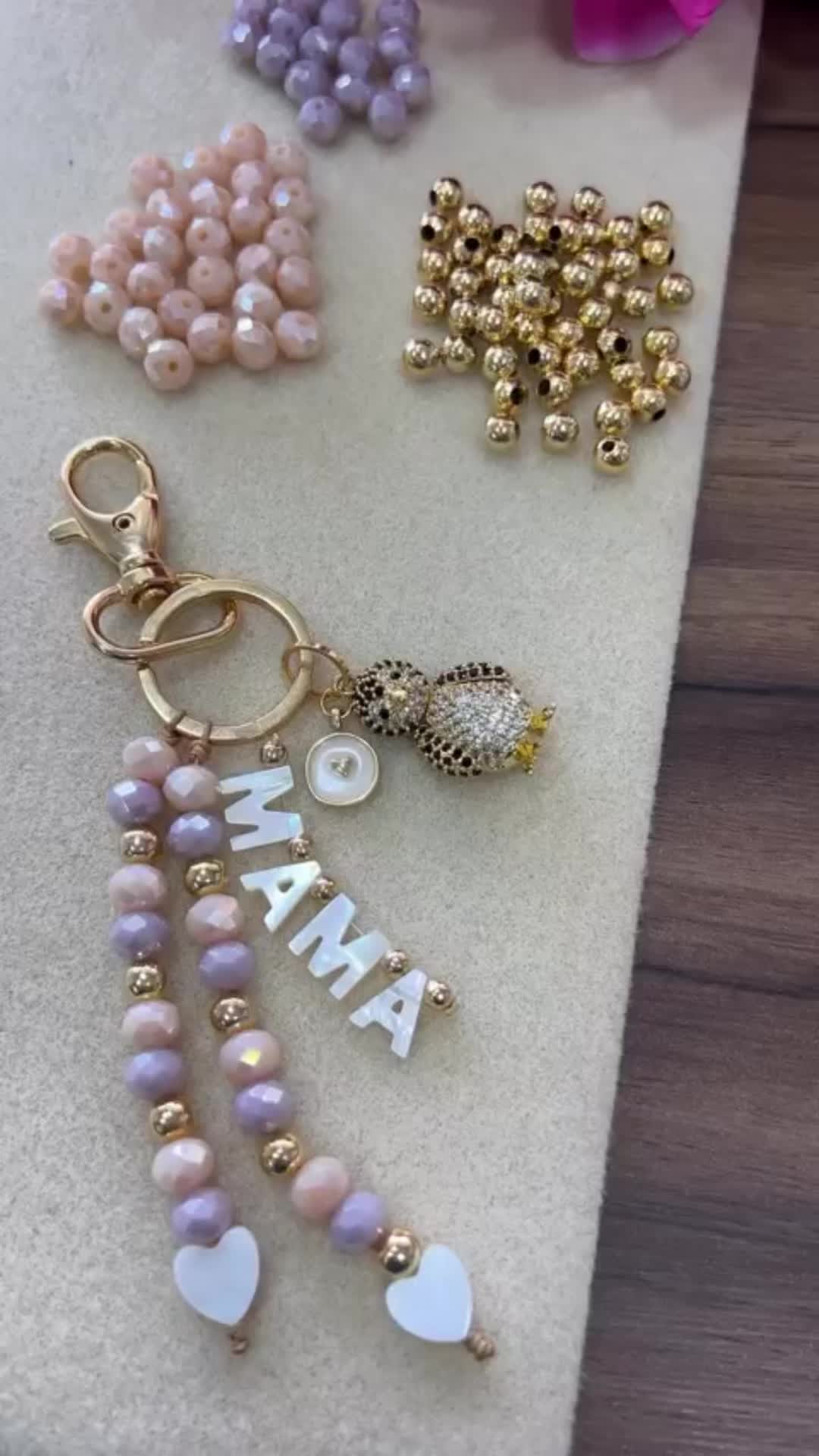 This may contain: some beads and charms are laying on a table next to each other with the word mama spelled in white letters