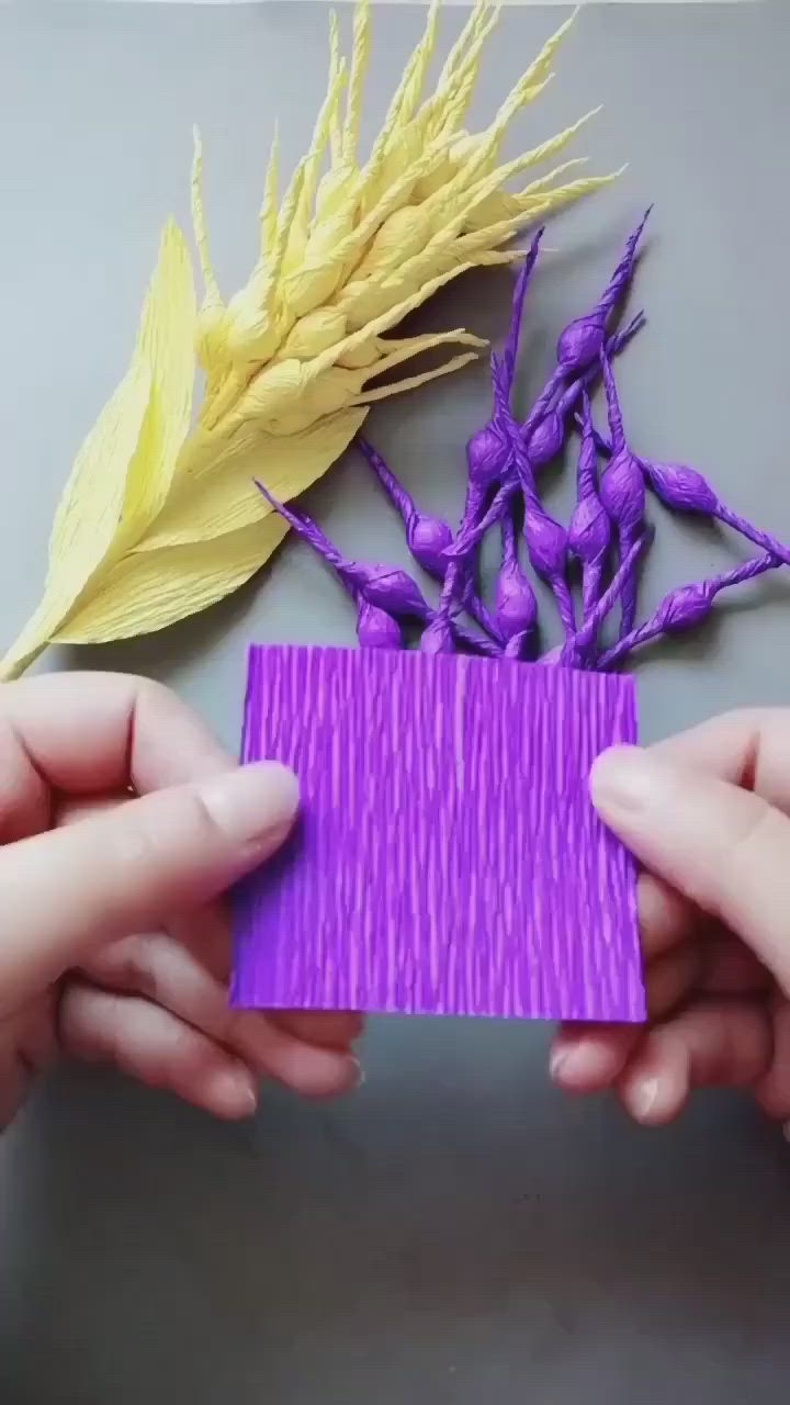 This may contain: two hands holding a piece of purple paper