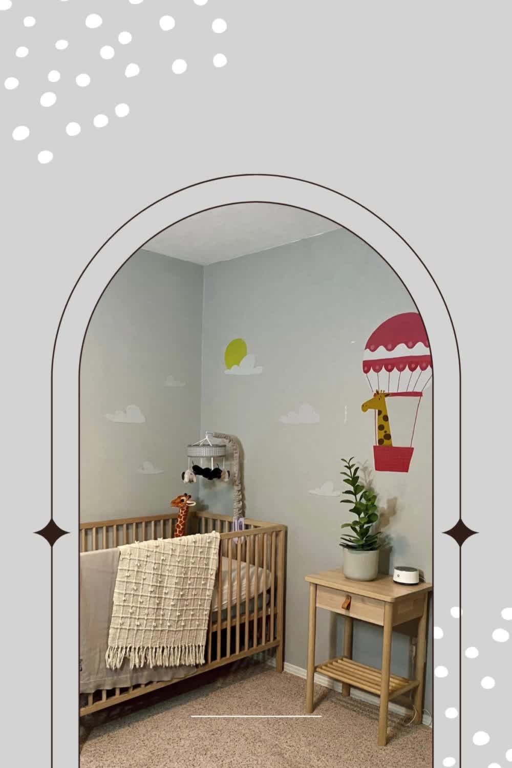 This may contain: a baby's nursery room with a giraffe wall sticker