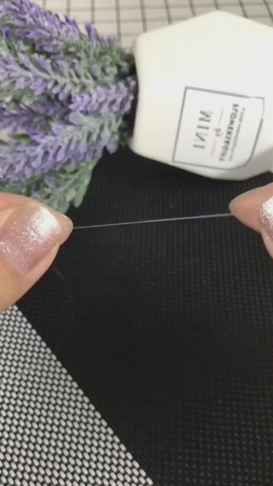 This may contain: someone is doing some crafting on their nails with lavender flowers in the back ground