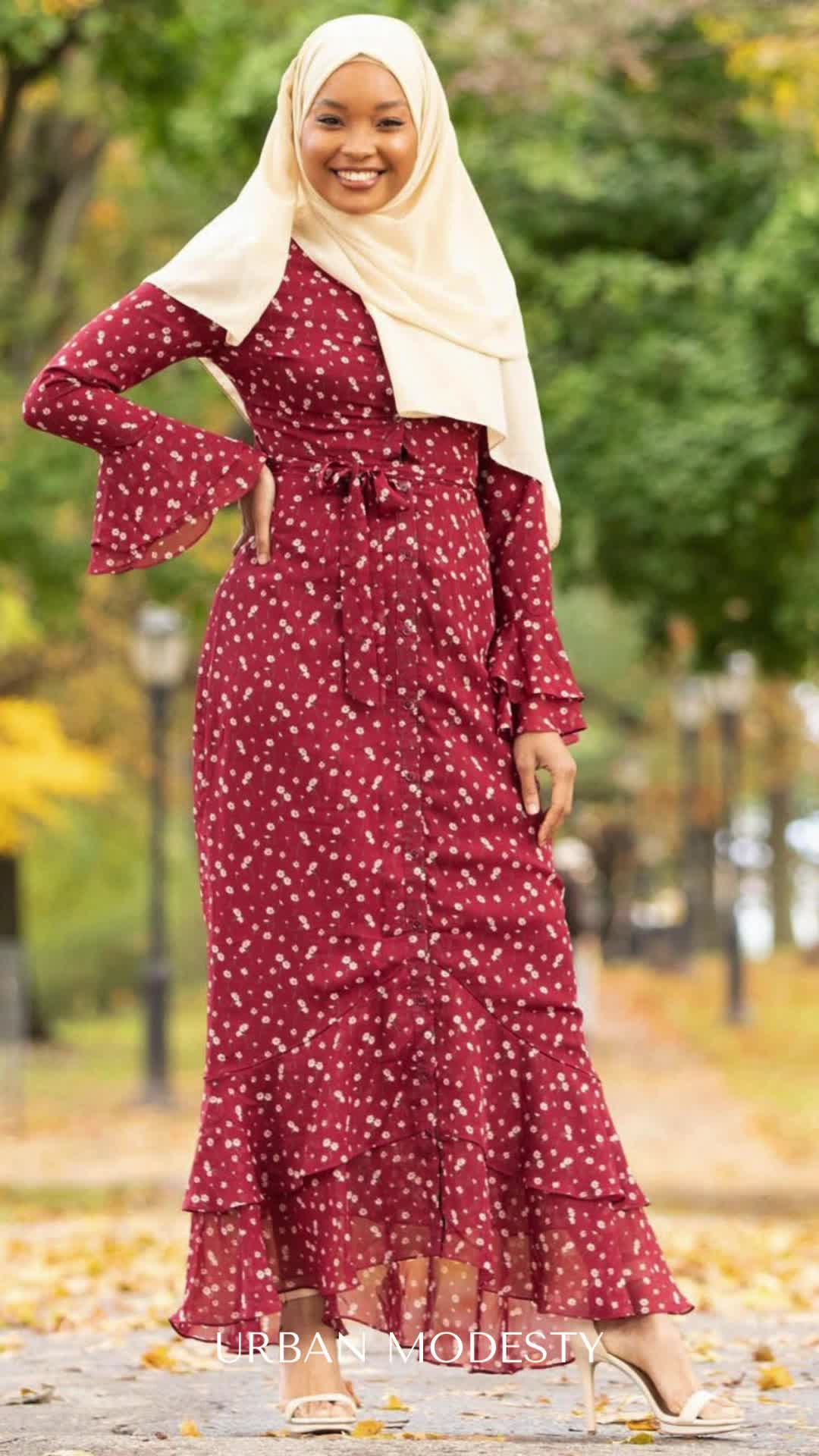 Discover versatility with our Casual Maxi Dress! Wear it buttoned down as a dress or open as a cardigan. Featuring a beautiful cream daisy floral print on red chiffon, with cascading ruffles and full lining for elegance and comfort. Perfectly paired with a beige chiffon hijab.