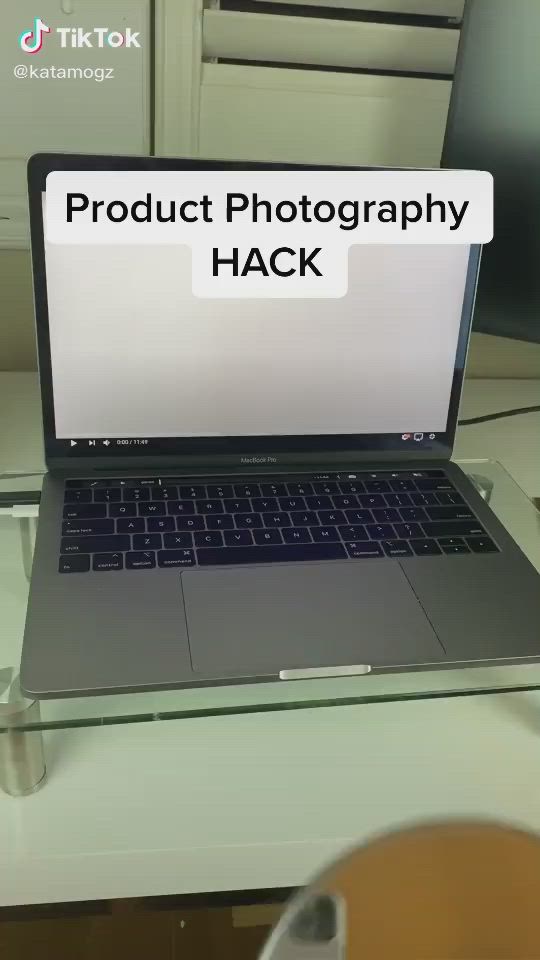 This may contain: an open laptop computer sitting on top of a glass desk with the words product photography hack above it