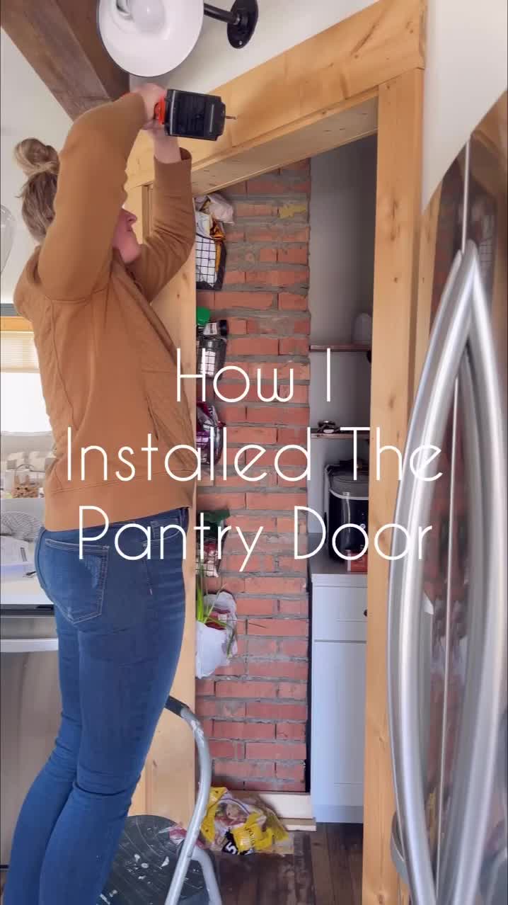 This may contain: a woman is installing the pantry door