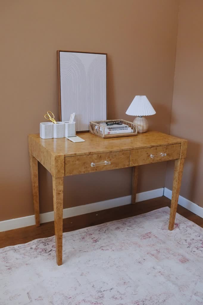 This timeless desk features a unique faux burl design that seamlessly blends traditional and modern aesthetics. Accented with elliptical clear acrylic handles, its two pull out drawers allows for easy storage. Anchor your office with this stunning desk or use as a console table in your bedroom, or entryway. Style with the Camden Coffee Table for a cohesive look. Contemporary design Faux burl 2 pull-out drawers with acrylic handles Assembly required, hardware included