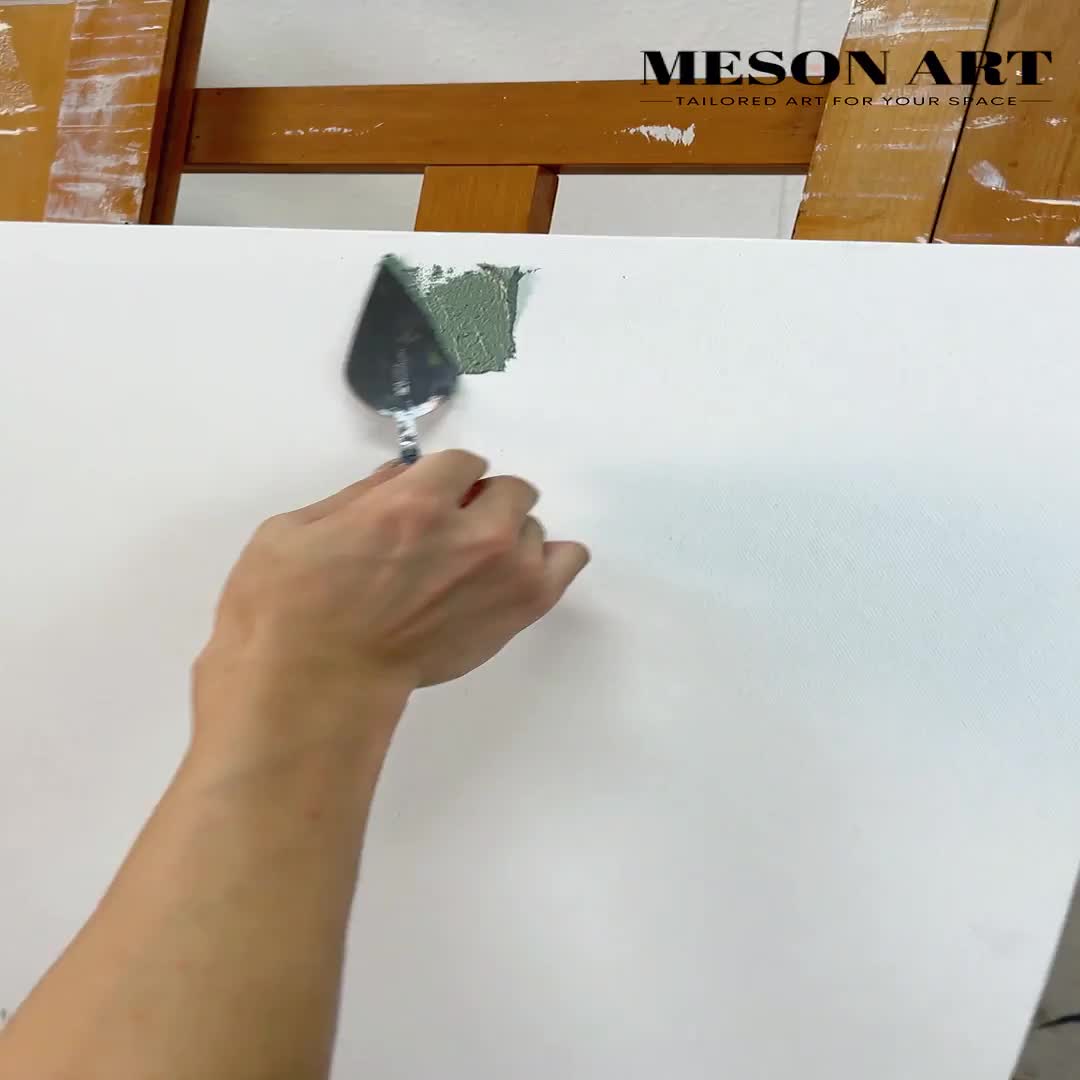 This may contain: a person holding a paintbrush and painting on a piece of paper with the words meson art