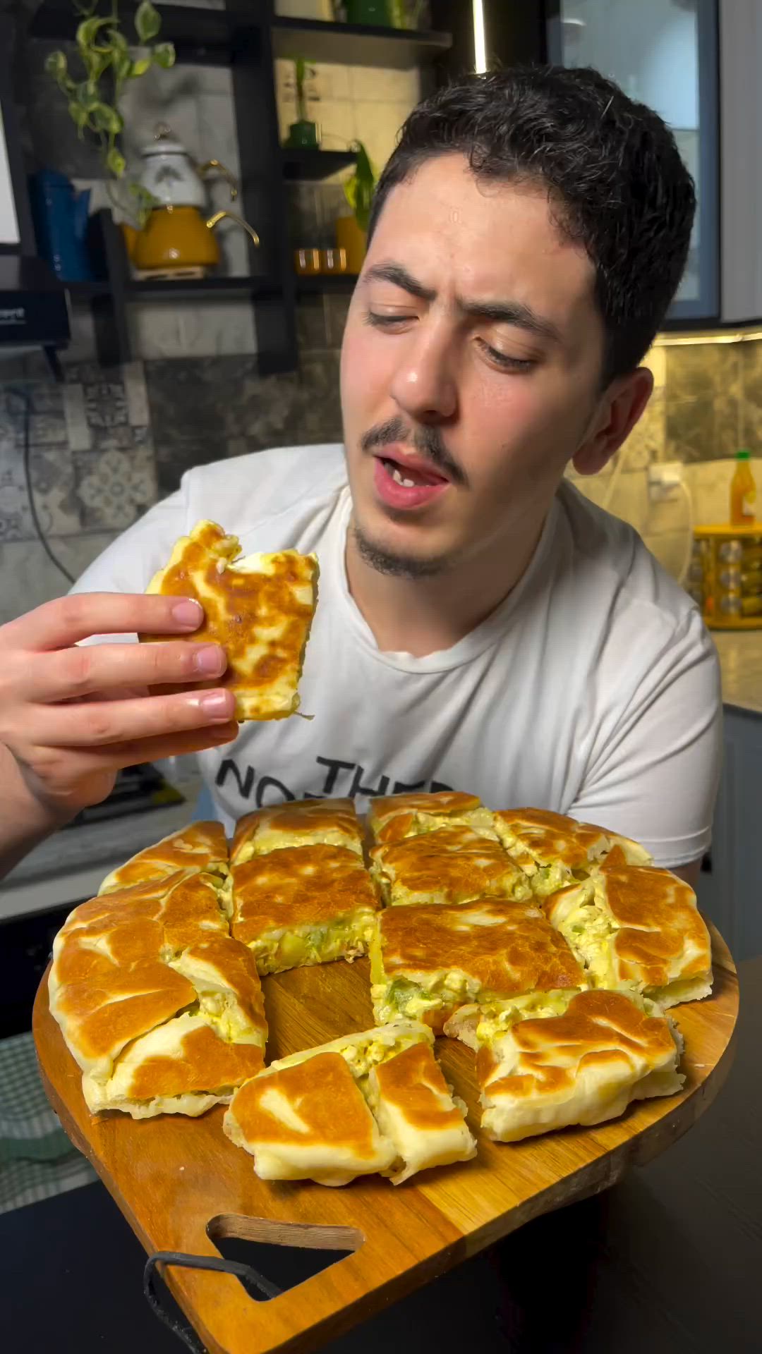 This may contain: a man is taking a bite out of some food on a wooden tray in front of him