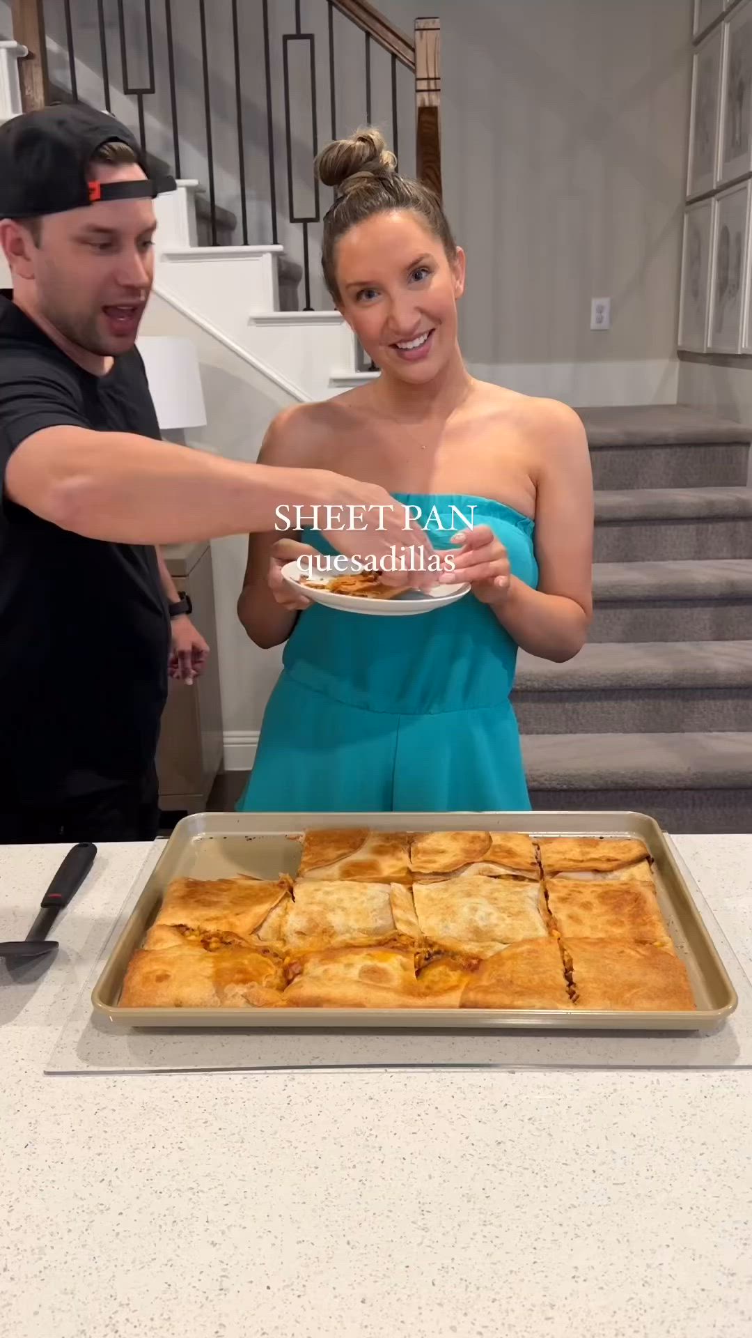 This may contain: a man and woman standing in front of a pan of food