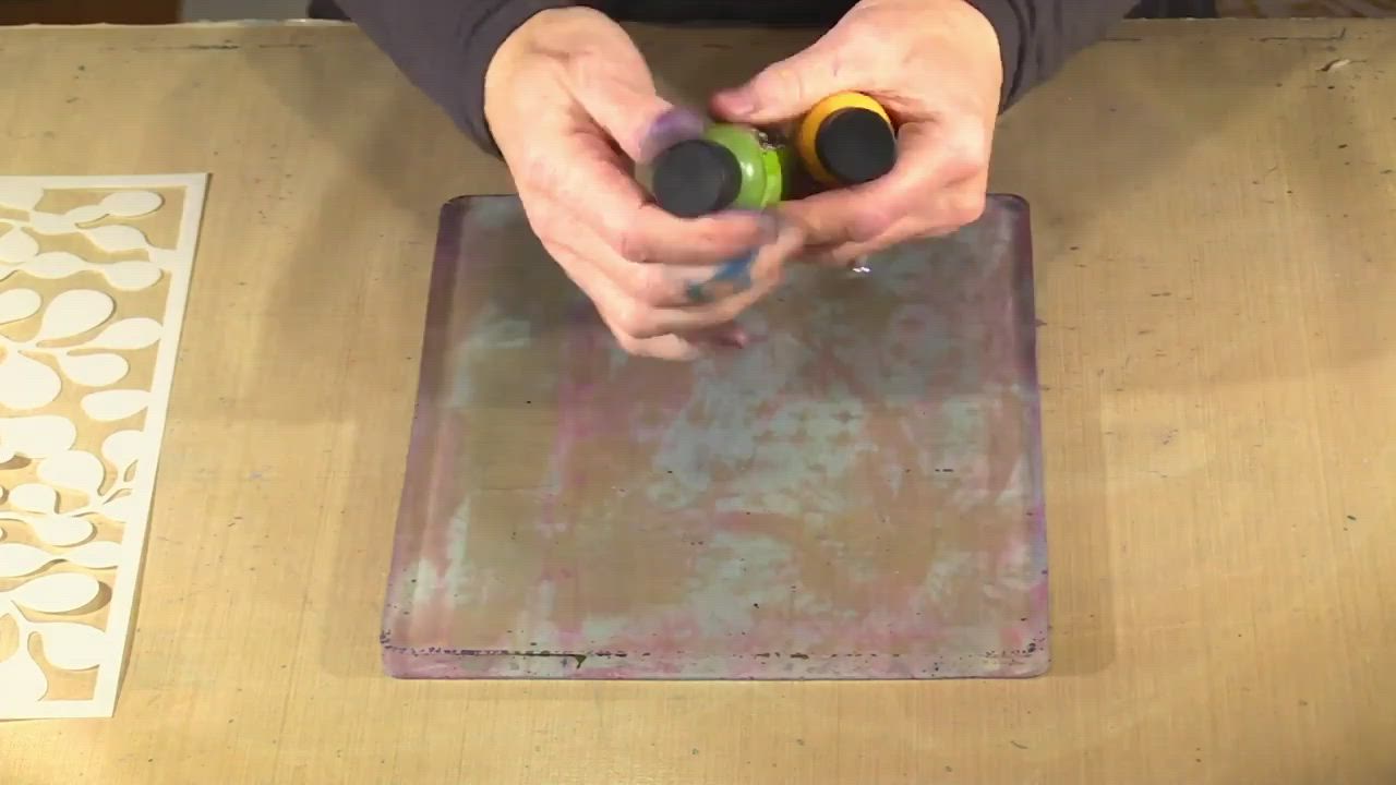 This may contain: a person with their hand on a purple and white square shaped object that is sitting on top of a wooden table