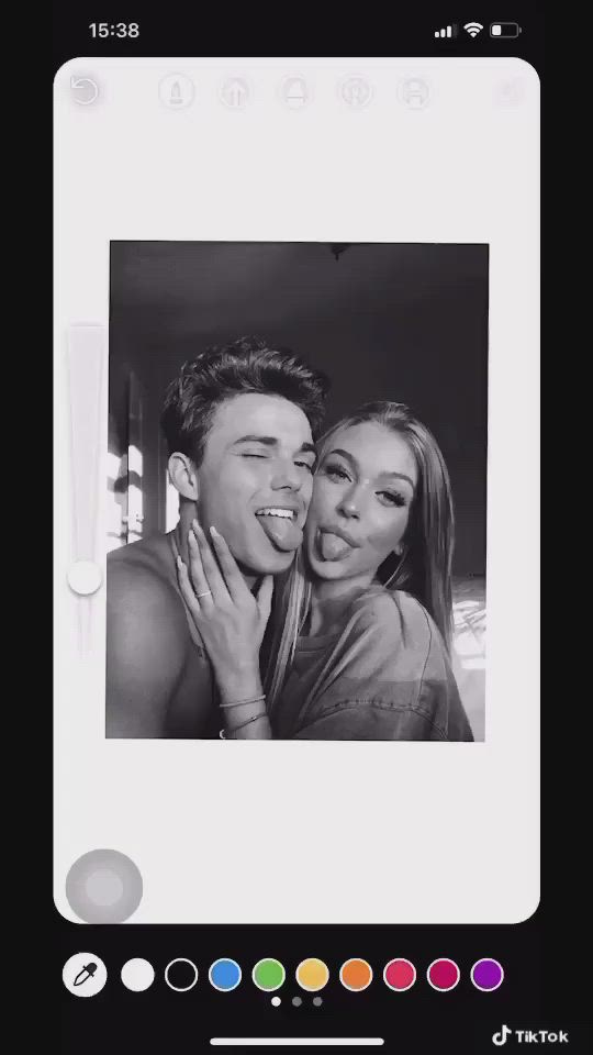 This may contain: a black and white photo of a man and woman smiling at the camera with their hands on each other's chest