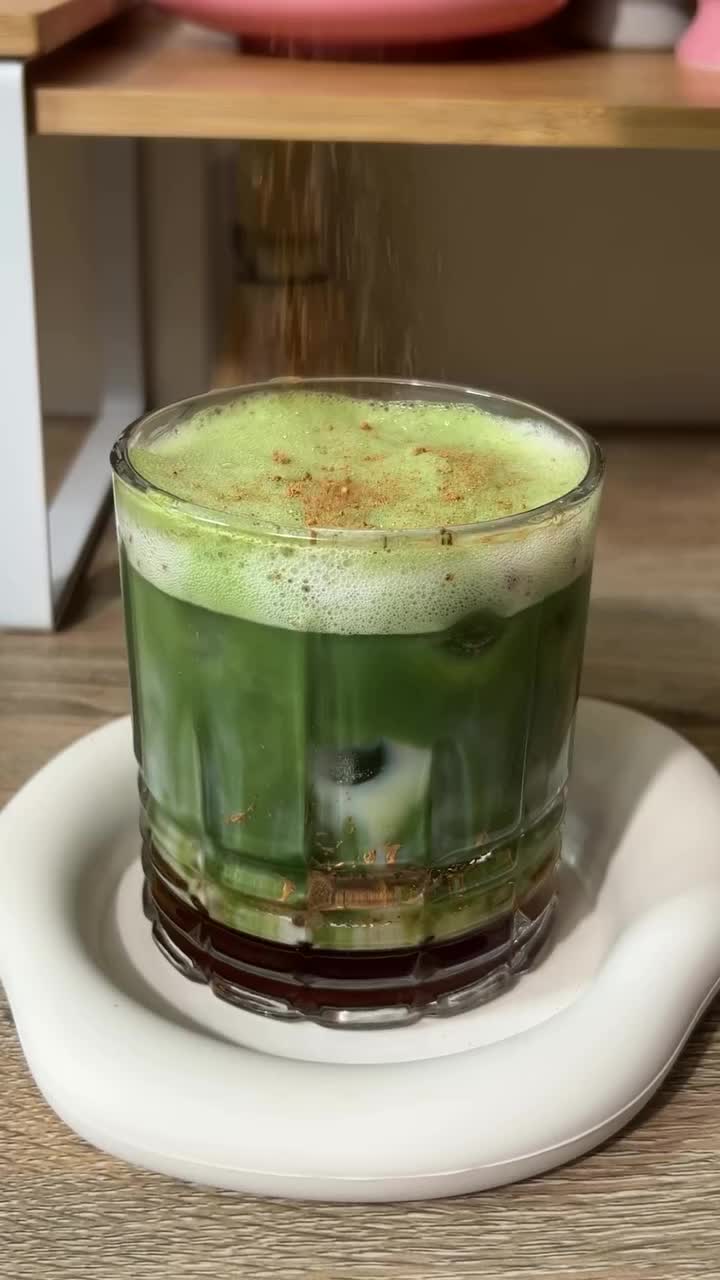 This may contain: a green drink sitting on top of a white plate