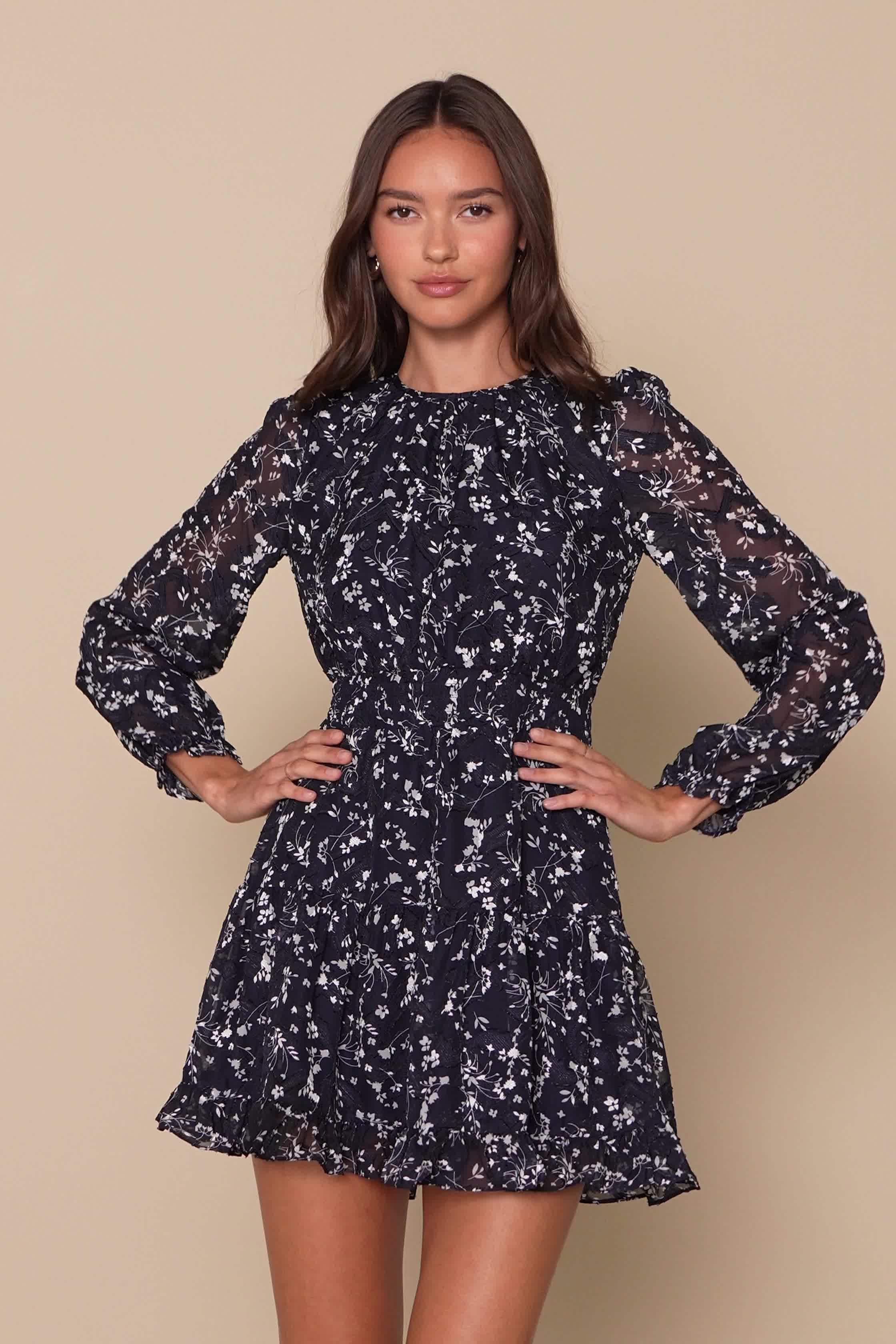 The Lulus Too Cute Navy Blue Floral Print Smocked Long Sleeve Mini Dress will have you lookin' like a dream! Lightweight woven chiffon, with a dainty white floral print and subtle jacquard embossing throughout, shapes this beautiful dress that falls from a rounded neckline into a relaxed bodice and sheer long sleeves with elastic ruffle cuffs. Elasticized, smocked waist tops an A-line skirt that ends at a flirty ruffled mini hem. Keyhole opening and button closure at back. Fit: This garment fits