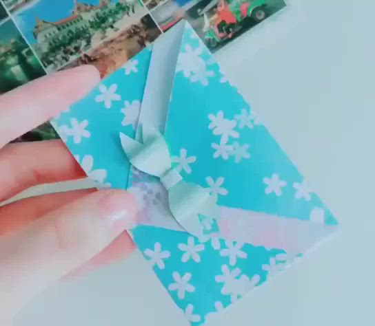 This may contain: someone is holding an envelope made out of origami and paper with the words lindaos envelopes written on it