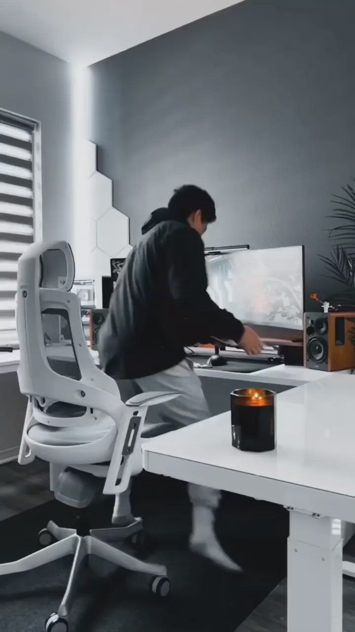 This may contain: a person sitting at a desk with a computer monitor and keyboard in front of him