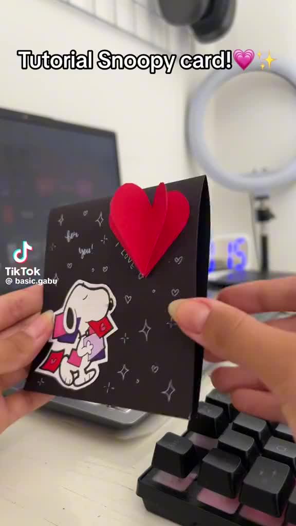 This may contain: someone holding up a small card with a heart on it