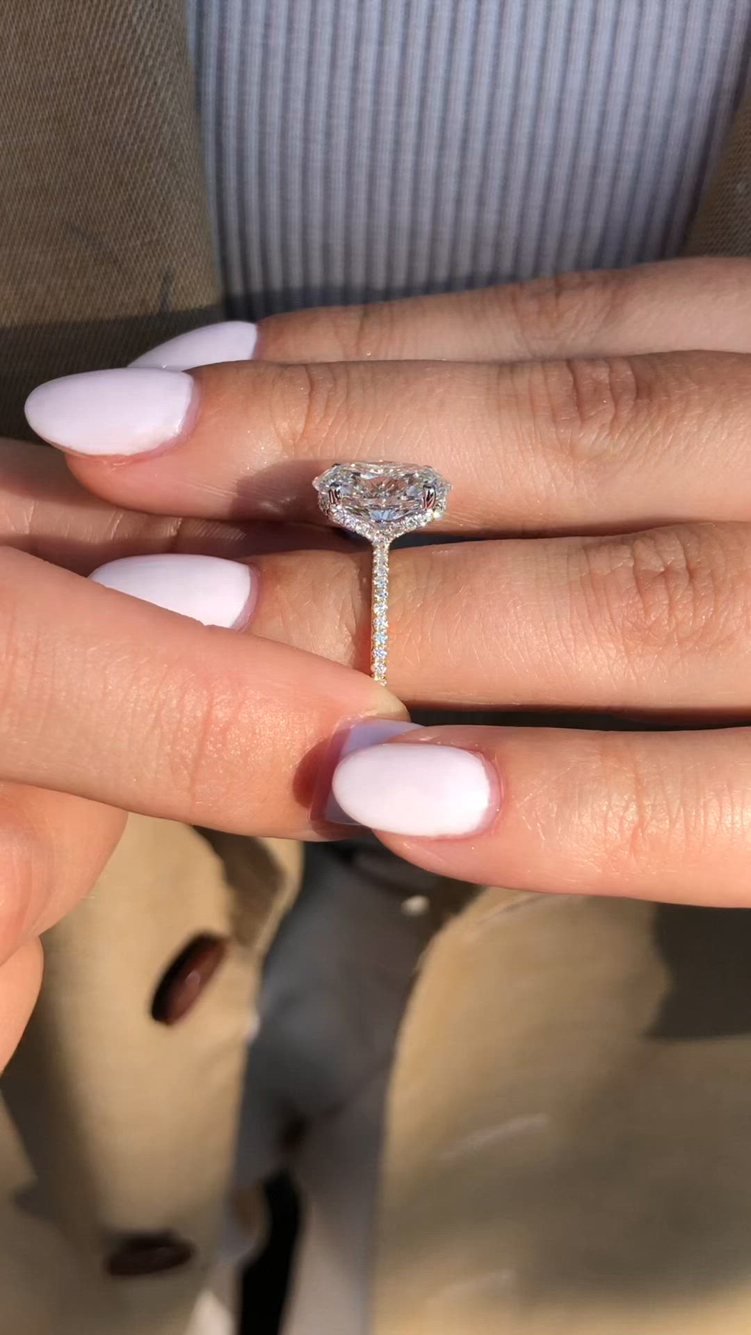 This may contain: a woman's hand with a diamond ring on top of her finger and an engagement band