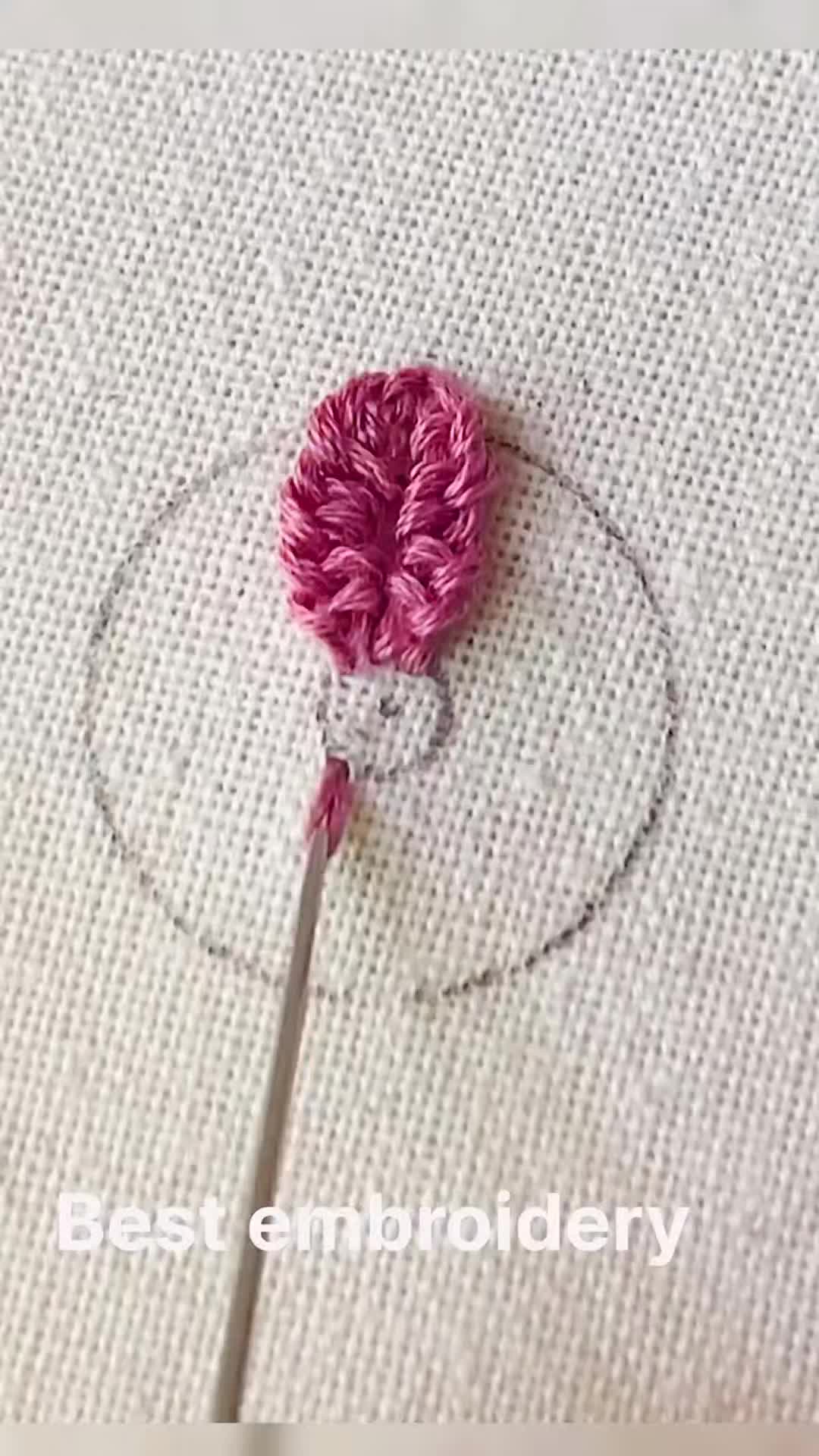 This may contain: a crochet hook with a pink flower on it