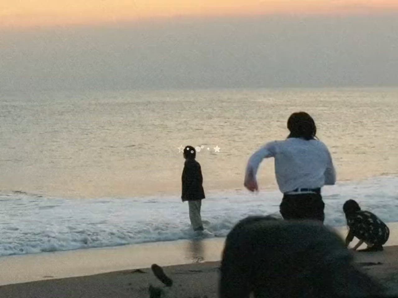 This may contain: a man standing on top of a beach next to the ocean