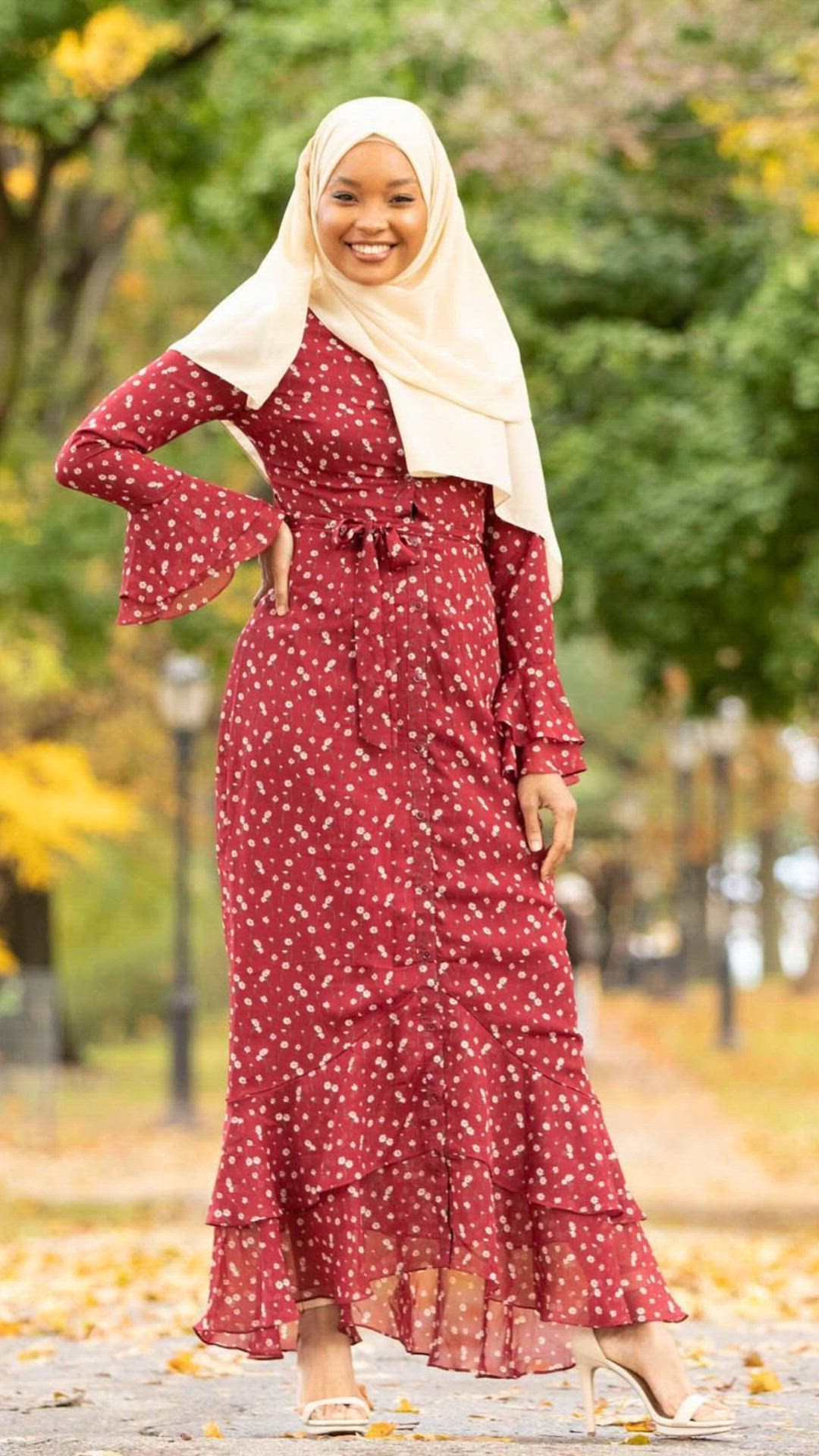 Tailor Made without the Hassle with our Custom Printed Fabric! The Maroon Daisy Button Down Maxi Dress is a master of all traits. It can be worn completely buttoned down as a maxi dress or open as a maxi cardigan. Lovely cream daisy floral print on a red chiffon canvas. Featuring cascading ruffles at hem and sleeves. Fully lined to ensure it's not see through. It features buttons to bottom. Paired with our Beige Chiffon hijab