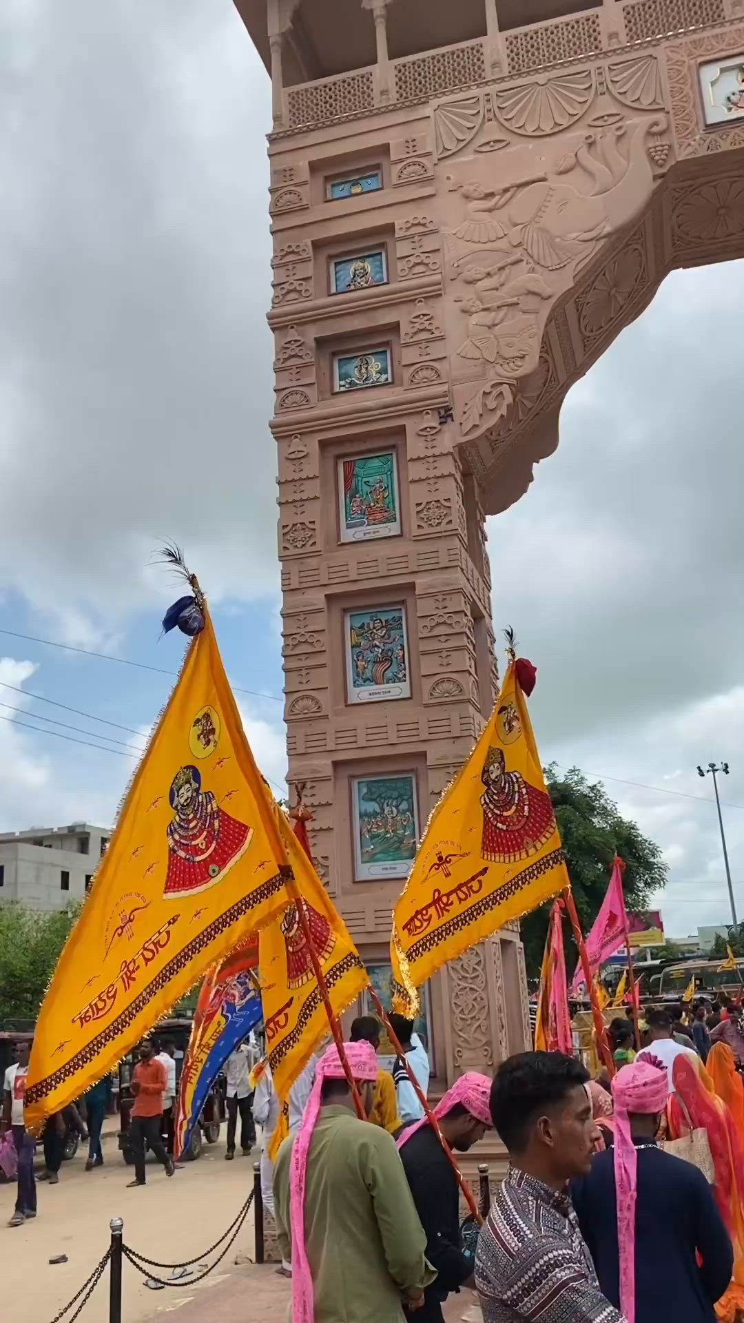 This may contain: some people are standing in front of a tall building with flags and banners on it