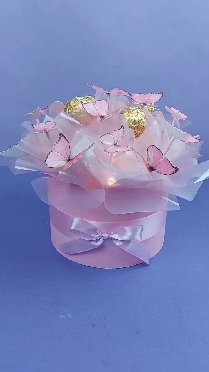 This may contain: a pink box with gold foiled butterflies in it