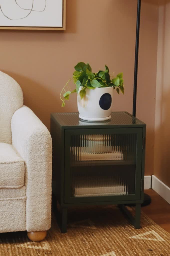 This meadow green end table updates a classic silhouette with a reeded glass window for a contemporary look. Inside, two shelves allow for convenient storage. Place next to your couch or place one on either side of your bed for a chic nightstand. Modern square design Reeded glass 2 shelf storage Assembly required, hardware included