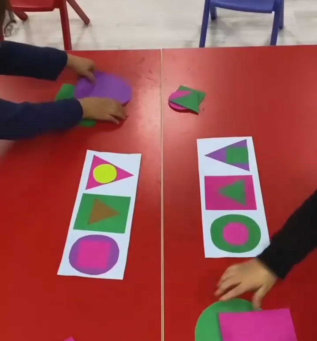 This may contain: two children are playing with construction paper on the table