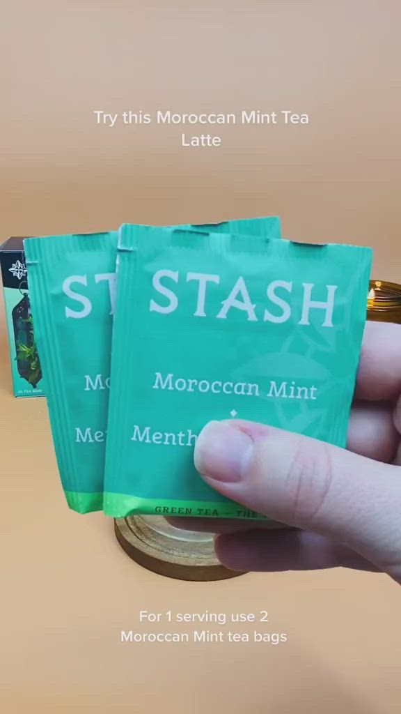 This may contain: three bags of stash mint tea sitting on top of a stack of coins with the title try this moroccan mint tea latte