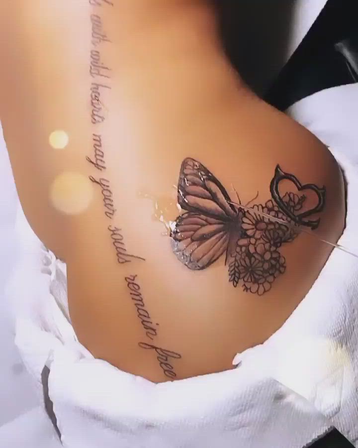 This may contain: the back of a woman's stomach with a butterfly tattoo on it