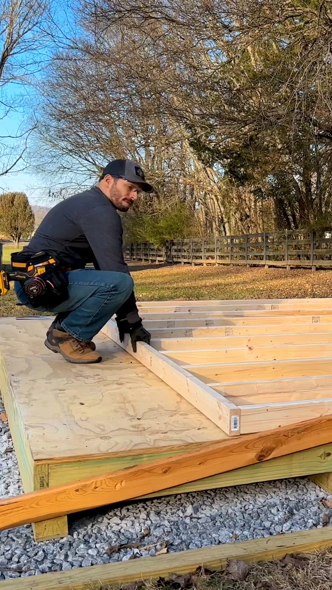 This may contain: a man kneeling down on top of a wooden floor next to a pile of wood